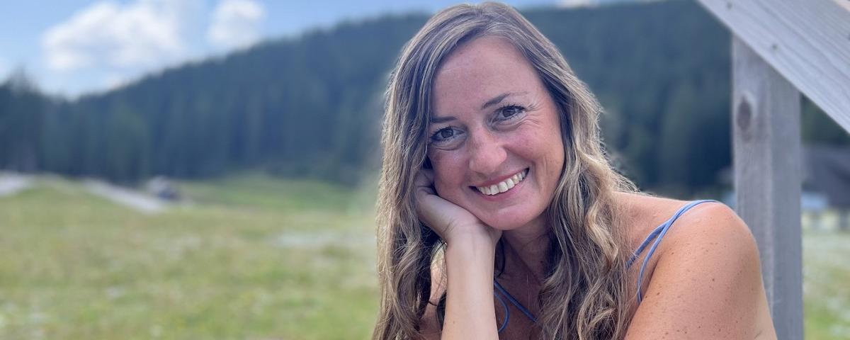 Andreja Poljanec v naravi, v ozadju gore